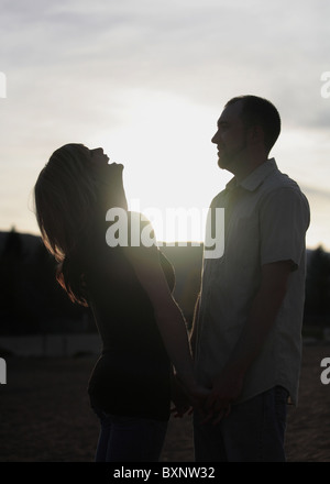 Silhouette des jungen Brautpaares zusammen im freien Stockfoto
