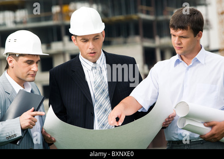 Porträt des Arbeitskreises der Bauherren Blick auf neues Projekt im Chefs Hände während einer der Männer, die auf etwas gerichtet Stockfoto