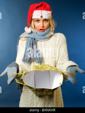 blonde Mädchen in Nikolausmütze mit Geschenktüte Stockfoto