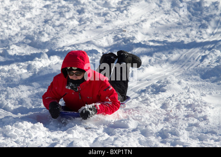 Ein Junge Rast hinunter einen Hügel im Riverside Park auf seinem Schlitten am Tag nach ein Schneesturm zwei Füße von Schnee auf New York City dumps Stockfoto
