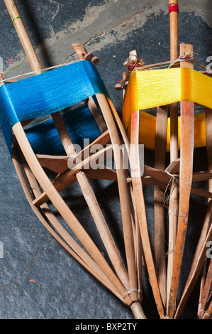 Farbige Seide auf Bambus Spindeln auf dem Webstuhl für die Sari's. Andhra Pradesh, Indien Stockfoto