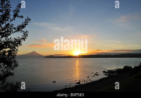 Schein über See Llanquihue, gelbe Sonnenaufgang zwischen Osorno und Calbuco Vulkane, von Puerto Varas Küste gesehen. Chile Stockfoto