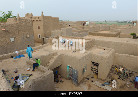 Leute sitzen auf dem Dach ihres Mudhouse in Djenné, Mali Stockfoto