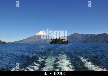 Blauer Himmel-Blick auf den schneebedeckten Vulkan Osorno vom Heck eines Bootes in die blaue Weite Todos Los Santos See, Chile Stockfoto