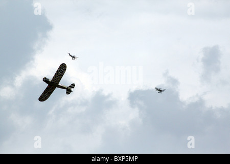 Zwei zweiten Weltkrieg Doppeldecker jagen ein Propellerflugzeug in einen Hund Kampf über grauen Himmel Stockfoto