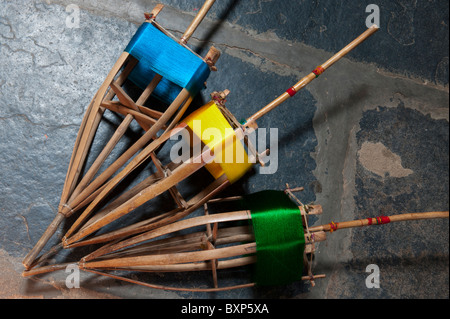 Farbige Seide auf Bambus Spindeln auf dem Webstuhl für die Sari's. Andhra Pradesh, Indien Stockfoto
