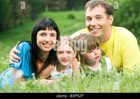 Foto von Vater umarmt seine Frau und zwei Töchter Stockfoto