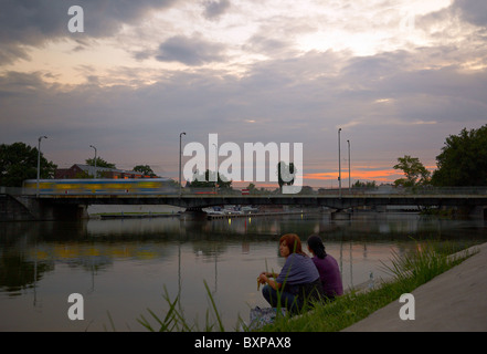 Zwei Frauen sitzen auf einer Bank oder in der Abenddämmerung, Wroclaw, Polen Stockfoto