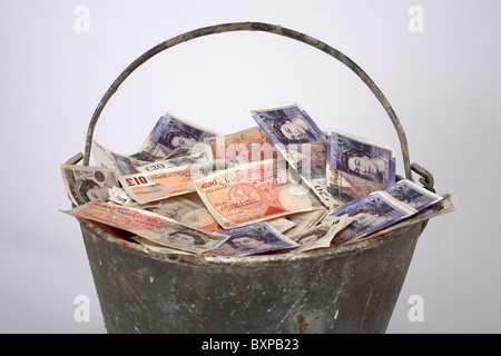 Metall-Eimer voller englischer Währung Stockfoto