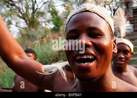 Ein traditionelle Stammes-Sänger führt tanzend und singend an den Victoria Fällen in Simbabwe. Stockfoto