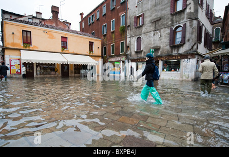 Shopper, waten durch Zoll Wasser während der Acqua Alta, Venedig, Italien Stockfoto