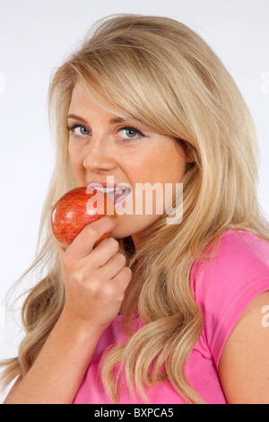 Junge kaukasischen blonde Frau Holding Apfel zeigt einen gesunden Lebensstil Stockfoto