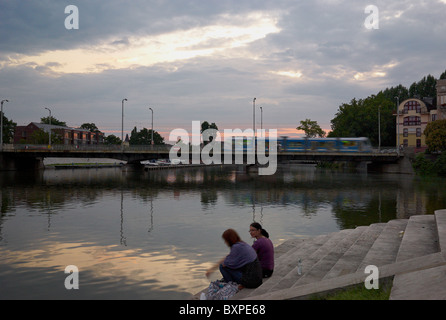 Zwei Frauen sitzen auf einer Bank oder in der Abenddämmerung, Wroclaw, Polen Stockfoto