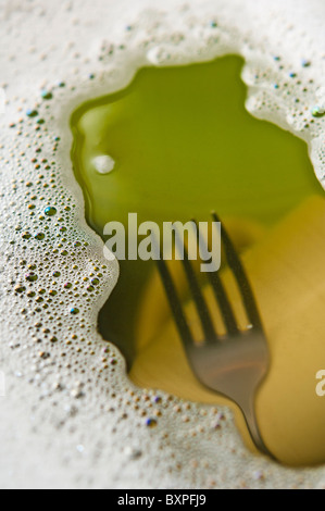 Gabel und Tasse in Seifenlauge Spülwasser Stockfoto