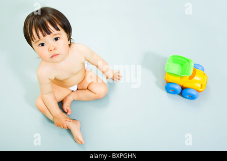 Bild der entzückende kleine Mädchen sitzen mit Spielzeug in der Nähe von Stockfoto