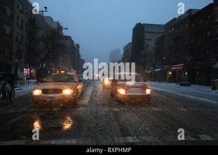 Autos und Taxis warten an der Ampel auf der 14th Street, Manhattan, New York, in der großen Schneesturm, der Weihnachten 2010 kam Stockfoto