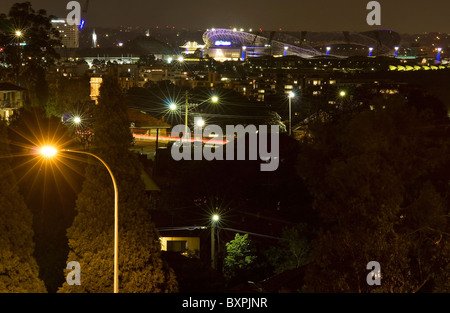 Eine urbane Nacht erleuchtet von Straßenlaternen in der Kulisse der Sydney Olympic Park. Stockfoto