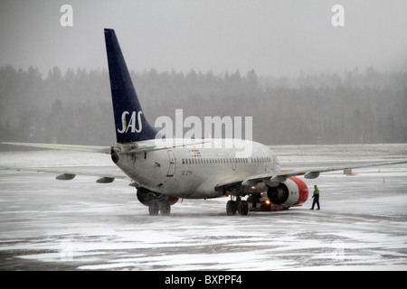 Flughafen Arlanda, Stockholm, Schweden. SAS-Flugzeugen auf dem Rollfeld in einem Schnee gebunden und nebligen Tag am Flughafen Arlanda. Stockfoto