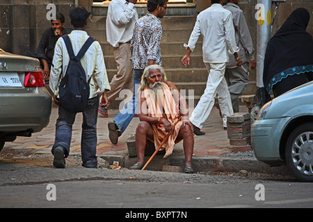 Der indische Sadhu saß in Mumbai, Indien, auf der Bordsteinkante Stockfoto