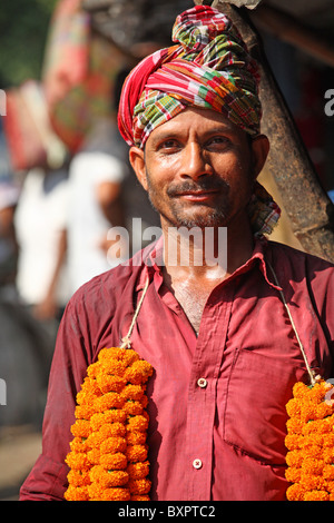 Indischer Mann posiert in Straße trägt Girlanden um Hals Stockfoto