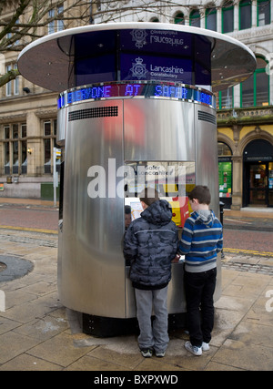 Zwei Kinder betrachten Polizei Informations-Kiosk oder Tardis, Stadtzentrum Preston, Lancashire, UK Stockfoto