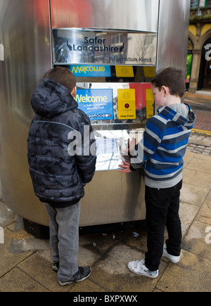 Zwei Kinder betrachten Polizei Informations-Kiosk oder Tardis, Stadtzentrum Preston, Lancashire, UK Stockfoto