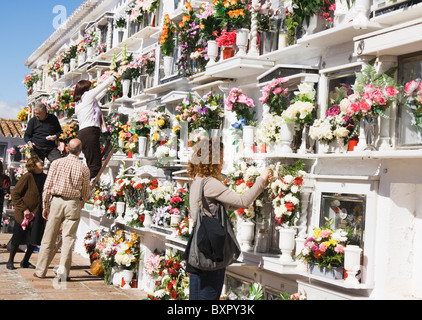 Menschen verlassen Blumen und Reinigung der Nischen ihrer lieben auf Allerheiligen auf dem örtlichen Friedhof. Stockfoto