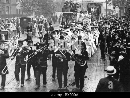 SUFFRAGETTEN elegant gekleidet Gruppe auf einen Marsch in London im Jahre 1908, flankiert von der Polizei und vor allem von Männern beobachtet Stockfoto