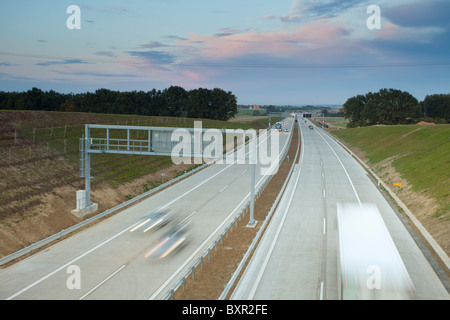 Autobahn in der Abenddämmerung mit fahrenden Fahrzeugen und Blick auf die Landschaft in der Tschechischen Republik. Stockfoto