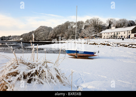 Red Wharf Bay (Traeth Coch), Isle of Anglesey, North Wales, UK. Schnee-Szene mit Boot an der Küste im winter Stockfoto