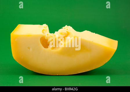 Gruyere Käse auf grünem Hintergrund isoliert Stockfoto