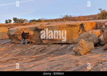 Mann beobachten große Peeling Blöcke auf Granit Batholith, Enchanted Rock Naturraum, Fredericksburg, Texas Stockfoto