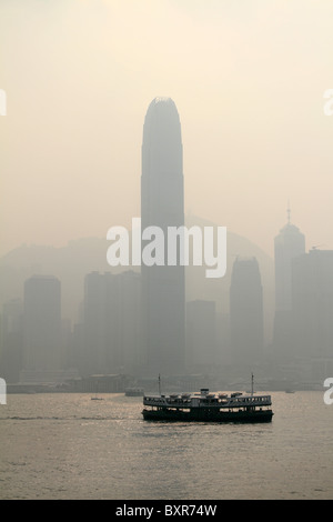 Die Star Ferry überquert den Hafen zwischen Kowloon und Central in Hong Kong, China gegen eine Skyline von Smog abgedeckt Stockfoto