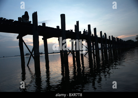 Die U Bein Teak-Brücke, die Taugthaman See in Amarapura in der Nähe von Mandalay in Myanmar umfasst. Stockfoto