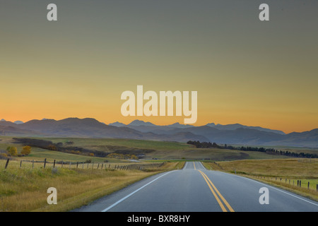 Rocky Mountain Silhouetten und Autobahn nach Sonnenuntergang, Alberta, Kanada Stockfoto