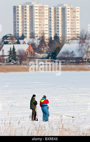 Zwei Männer auf einem zugefrorenen See am Stadtrand von Kopenhagen Angeln Stockfoto