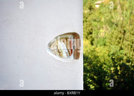 Betonwand mit farbigen Stein und eingelegten Sfonfo Lärchenwald im Sommer Stockfoto