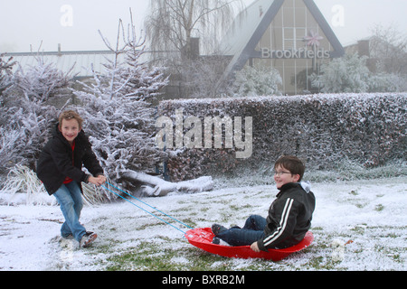 zwei neun Jahre alten Jungen spielen im künstlichen Schnee Schnee-Business-Unternehmen im Brookfields Garden Centre festgelegten Stockfoto