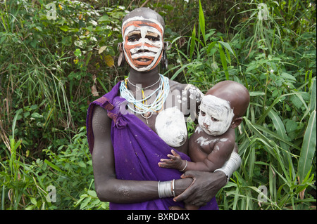 Surma Frau mit Körper Gemälde und hält ein Baby Säugling Kibish Omo River Valley Äthiopien