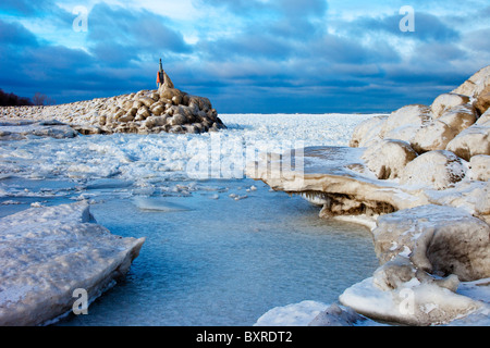 Eisfluss um einen Steinbrecher nahe dem Ufer des Lake Erie in Madison, Ohio, USA Stockfoto