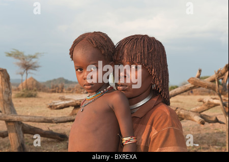 Hamar junge Frau mit rotem Lehm im Haar und ihr Kind, Omo-Tal, Südliches Äthiopien-Afrika Stockfoto