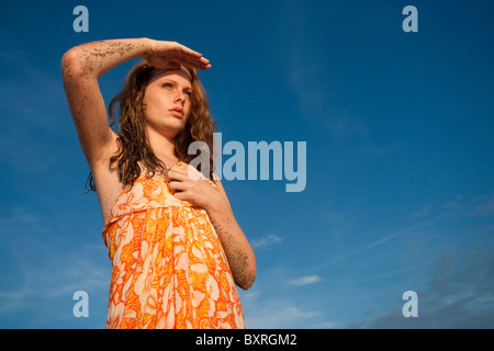 Junge Frau am Strand mit Blick in die Ferne Stockfoto