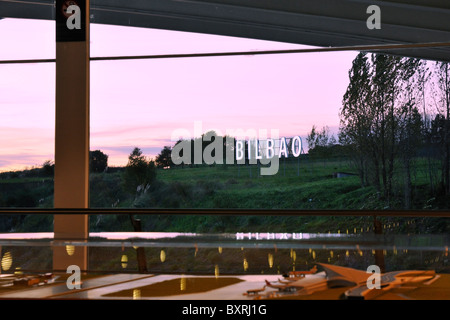 Blick durch das Flughafen-Fenster, die großen Buchstaben Bilbao, Spanien in der Zeit der Dämmerung Stockfoto