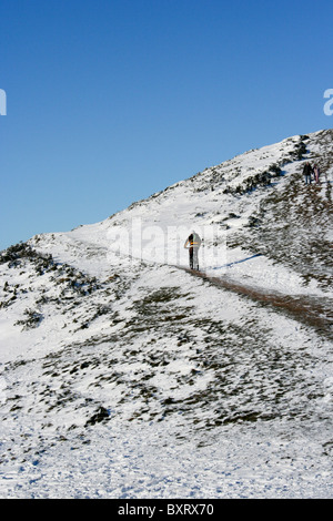 Mountainbiker im Schnee auf den Hügeln von Malvern, Worcestershire Stockfoto