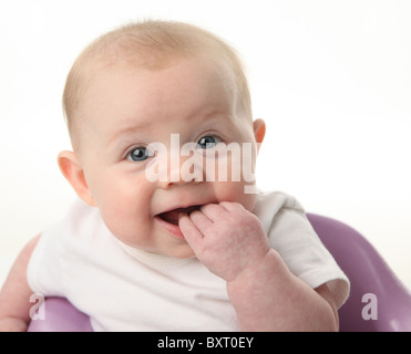 Nahaufnahme Portrait eines niedlichen Babys kauen auf Finger auf weißem Hintergrund Stockfoto