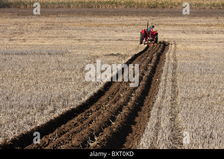 Landwirt mit einem Traktor ein Feld in einem Pflügen Match zu pflügen, Großbritannien Stockfoto