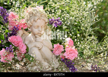 Kleine Engel Figur im Blumenbeet Stockfoto