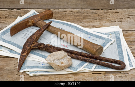 Zwei alte Bergbauprospektoren, die auf Silberzertifikaten aufliegen. Stockfoto