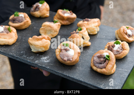 Rindfleisch und Yorkshire Pudding Kanapees mit Meerrettichsauce auf einer Tafel Serviertablett Stockfoto
