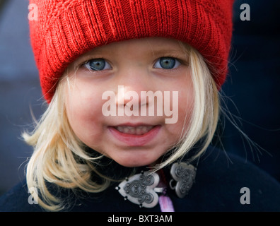 Eine ziemlich 3 jährige blonde Mädchen, gekleidet in einen roten Wollmütze Stockfoto